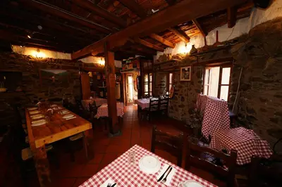 a dining room with tables and chairs in a restaurant at Linos Inn in Kakopetria