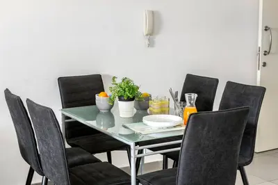 a dining room table with black chairs and a green table at AirBnSea City Centre Side Sea view Apartments in Larnaka