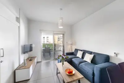 a living room with a blue couch and a table at AirBnSea City Centre Side Sea view Apartments in Larnaka