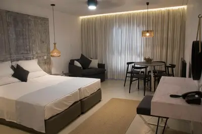 a bedroom with a bed and a table and chairs at Hylatio Tourist Village in Pissouri