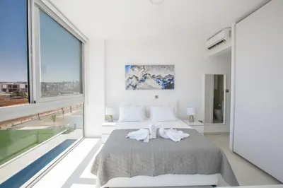 a bedroom with a bed and a large window at Villa Alana in Protaras