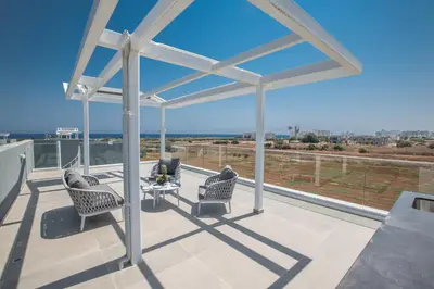a patio with two chairs and a table on a balcony at Villa Alana in Protaras
