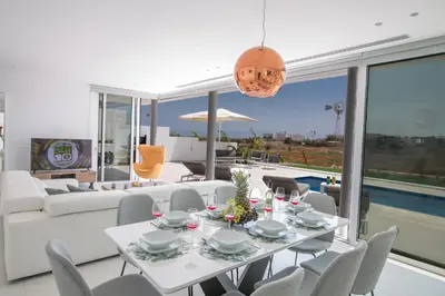 a dining room with a white table and chairs at Villa Alana in Protaras