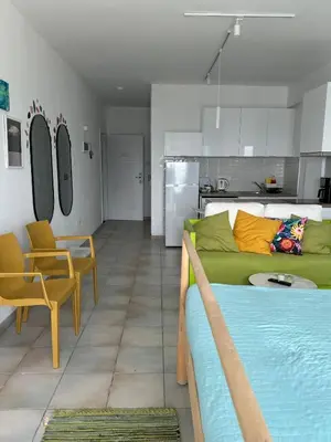 a living room with a green bed and a kitchen at Krasas Beach in Larnaka