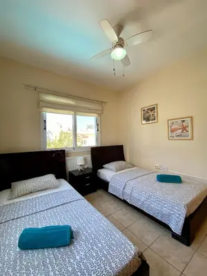 a bedroom with two beds and a ceiling fan at Sea View Villa in Agia Thekla in Ayia Napa
