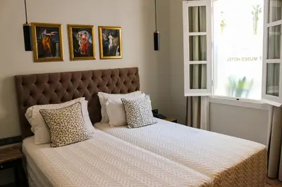 a bedroom with a large bed with two pillows at 9 Muses Hotel in Larnaka