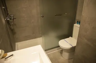 a bathroom with a shower with a toilet and a sink at Jimmy's Suites in Larnaka