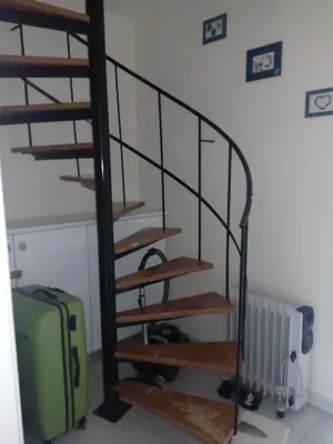 a spiral staircase with a green suitcase in a room at Lighthouse in Larnaka
