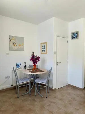a dining room with a table and chairs with flowers on it at Detached Cozy Studio in Paralimni