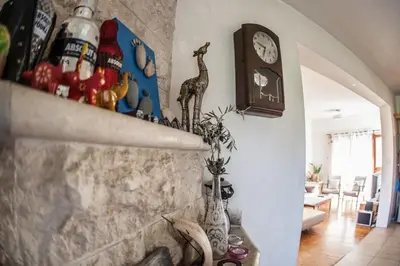 a living room with a wall with a clock and vases at Lania Royal Oak House by TrulyCyprus in Lania