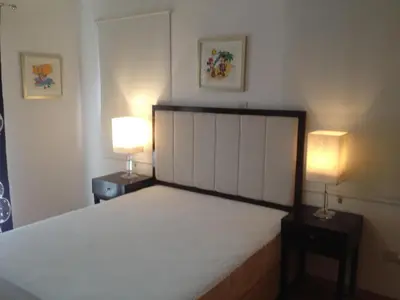 a bedroom with a large bed with two lamps at Lania Royal Oak House by TrulyCyprus in Lania