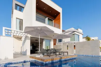 a house with a swimming pool and two umbrellas at Napa Hills Seaview Villas in Ayia Napa