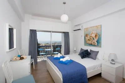 a bedroom with a large bed and a balcony at White Arches Apt #1 by TrulyCyprus in Limassol