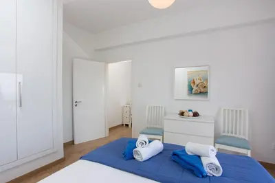 a bedroom with a blue bed and two blue chairs at White Arches Apt #1 by TrulyCyprus in Limassol