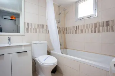 a bathroom with a toilet and a tub and a sink at White Arches Apt #1 by TrulyCyprus in Limassol