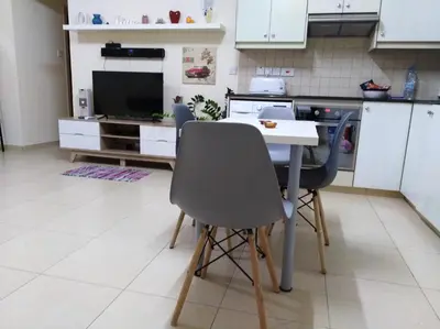 a kitchen with a table and chairs and a television at Xylophagou Larnaca Ayia Napa 1 bedroom apartment in Xylophaghou