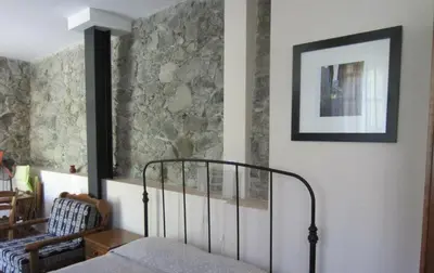 a bedroom with a bed and a picture on the wall at Ayios Andronikos Agrotourism House in Kalopanayiotis