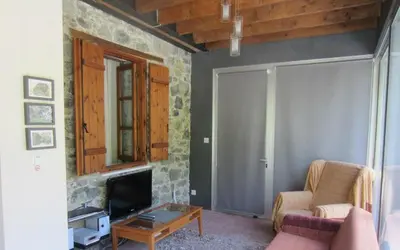 a living room with a couch and a tv at Ayios Andronikos Agrotourism House in Kalopanayiotis