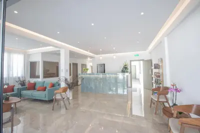 a living room with a blue couch and chairs at Pavlinia Hotel & Apartments in Ayia Napa