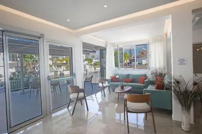 a living room with a couch and chairs and a table at Pavlinia Hotel & Apartments in Ayia Napa