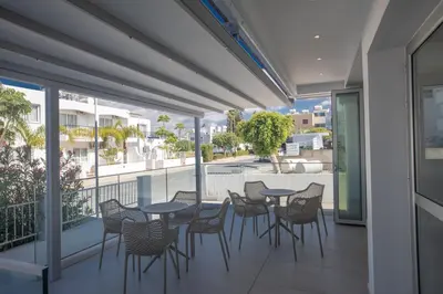 a patio with tables and chairs on a balcony at Pavlinia Hotel & Apartments in Ayia Napa