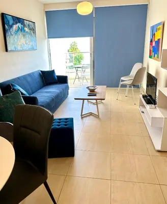 a living room with a blue couch and chairs at PALLINIO COURT 402 Fig Tree Bay- Protaras Beach, IASONOS STR 7A in Protaras