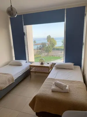 two beds in a room with a large window at PALLINIO COURT 402 Fig Tree Bay- Protaras Beach, IASONOS STR 7A in Protaras