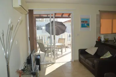 a living room with a couch and a table with an umbrella at Kapparis Penthouse in Paralimni
