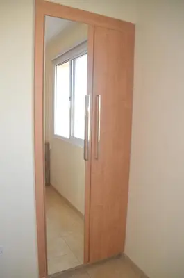 a wooden door with a mirror in a room at Kapparis Penthouse in Paralimni