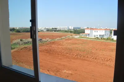 a view of a dirt field from a window at Kapparis Penthouse in Paralimni