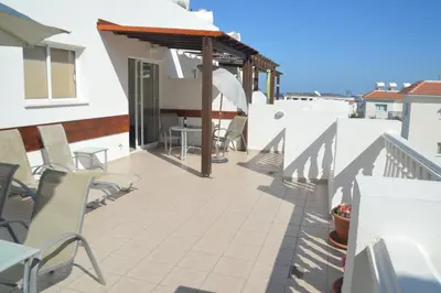 a patio with chairs and tables on a building at Kapparis Penthouse in Paralimni