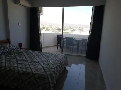 a bedroom with a bed and a table with a view at Great views apartment. in Limassol