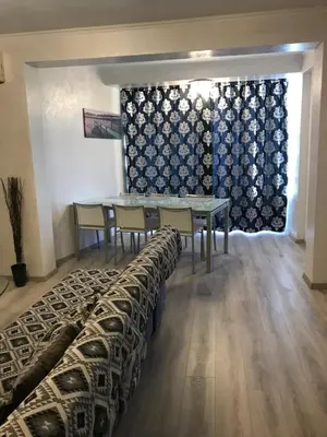 a dining room with a table and chairs and a curtain at Galaxy court modern apartment in Limassol
