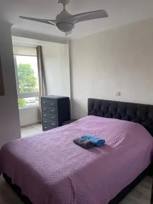 a bedroom with a purple bed with a purple blanket at Galaxy court modern apartment in Limassol