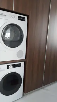 a washing machine sitting next to a wooden cabinet at Mobina Villas in Larnaka
