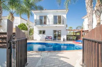 a villa with a swimming pool in front of a house at Villa Papantonia in Protaras