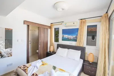 a bedroom with a large white bed and windows at Protaras View Villa 5 in Protaras