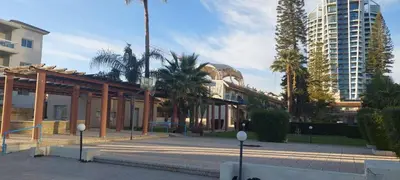 a building with palm trees and a tall building at Palm beach 14 in Limassol