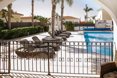 a balcony with chairs and a swimming pool at Sunset Villa private complex heated pool in Ayia Napa