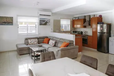 a living room with a couch and a kitchen at Sunset Villa private complex heated pool in Ayia Napa