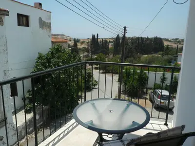 a table on a balcony with a view of a street at Esperando in Maroni