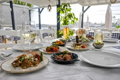 a table with plates of food and a glass of wine at Chrysomare Beach Hotel & Resort in Ayia Napa