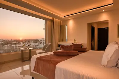 a hotel room with a bed and a large window at Chrysomare Beach Hotel & Resort in Ayia Napa
