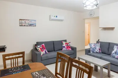 a living room with a couch and a table and chairs at EURO CARISSA FLAT 101 in Larnaka