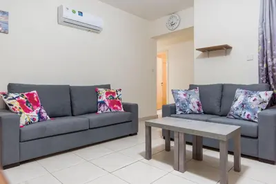 a living room with two couches and a table at EURO CARISSA FLAT 101 in Larnaka