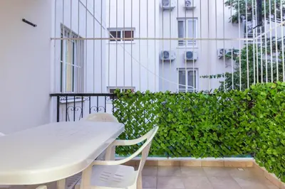 a white table and chairs on a balcony with a building at EURO CARISSA FLAT 101 in Larnaka