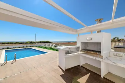 a patio with a fireplace and a swimming pool at Infinity View Villa in Ayia Napa