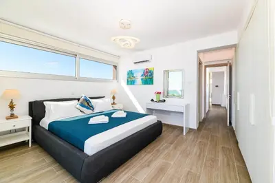 a bedroom with a king sized bed and a window at Infinity View Villa in Ayia Napa