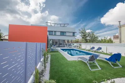 a backyard with a swimming pool and a house at Colour Residences in Protaras