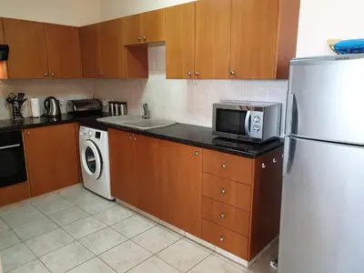 a kitchen with a refrigerator and a washer and dryer at Mediterranean dream in Voroklini